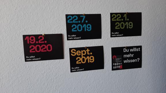 An einer weißen Wand hängen fünf Postkarten mit verschiedenen Daten von menschenfeindlichen Vorkommnissen in Heusenstamm.