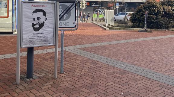 Ein Gedenkplakat mit Gesicht von Sedat Gürbüz ist in einem Plakatständer auf dem Roten Platz in der Dietzenbacher Altstadt aufgestellt. 