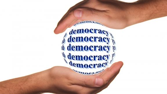Schützende Hände um das Wort "Democracy" (deutsch: Demokratie)_Lizenzfreies Bild von Gerd Altmann auf Pixabay